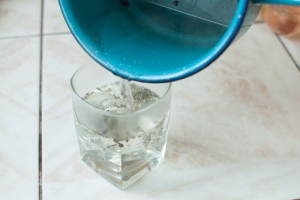 Agregar agua caliente a la salvia en un vaso